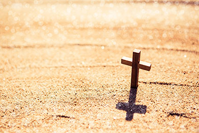 sandy beach with small wooden cross